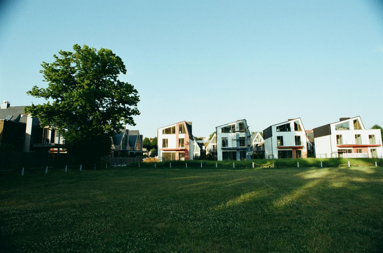 a row of houses sitting on top of a lush green field